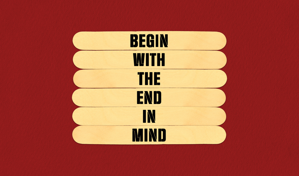 Begin in End of Mind Symbol. Concept word Begin With The End In Mind on beautiful wooden stick. Beautiful Red Chart Paper Background. Business and Begin in End of Mind concept. Copy space